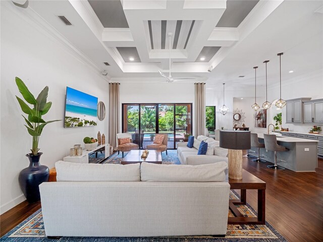 living area with dark wood-style floors, coffered ceiling, visible vents, and crown molding