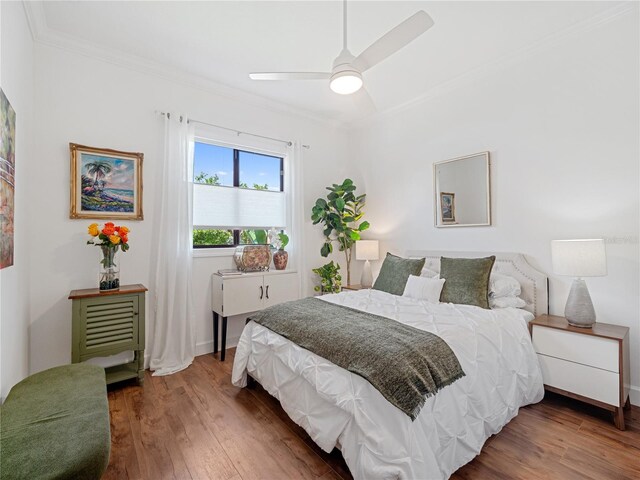 bedroom featuring baseboards, crown molding, a ceiling fan, and wood finished floors