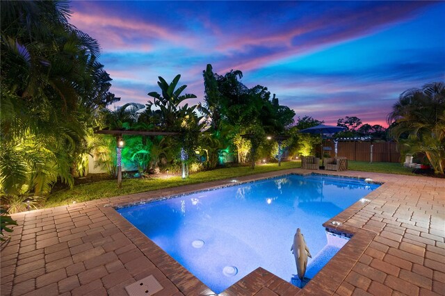 pool with a patio and fence