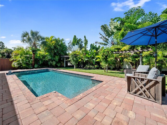 view of swimming pool with a fenced in pool, fence, a pergola, and a patio