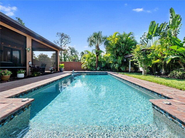 view of swimming pool featuring a fenced in pool, a sunroom, and fence