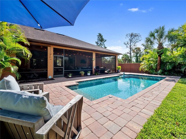 view of pool with a fenced in pool, a sunroom, fence, and a patio