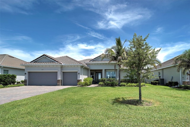 view of front of home featuring a garage, central AC unit, and a front lawn