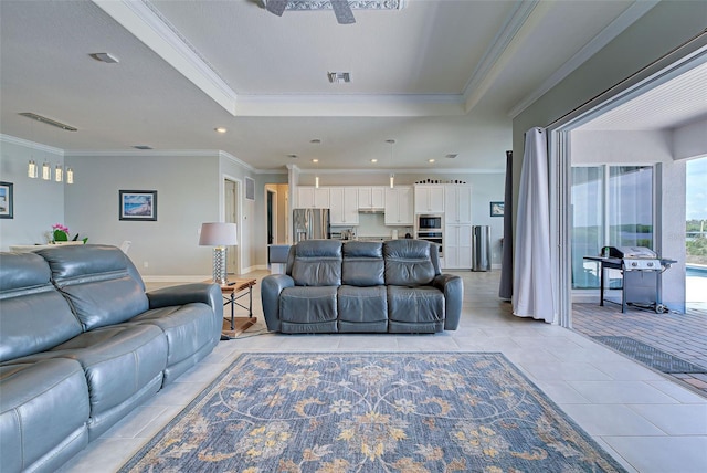 living room with a raised ceiling, ornamental molding, and light tile patterned floors