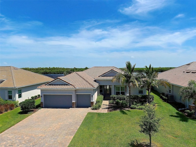 view of front facade featuring a garage, central AC unit, and a front lawn