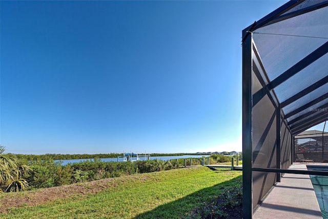 view of yard with a water view and glass enclosure