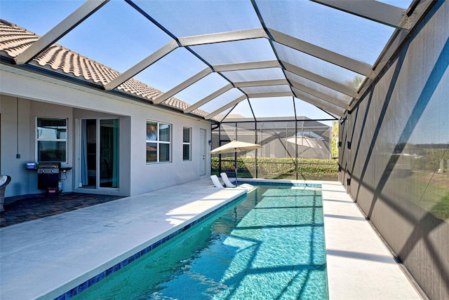 view of swimming pool with a grill, glass enclosure, and a patio area