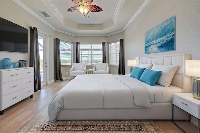 bedroom with access to exterior, ornamental molding, a raised ceiling, and light wood-type flooring