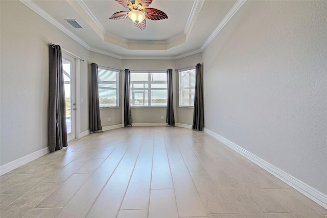 empty room with a tray ceiling, ornamental molding, and ceiling fan