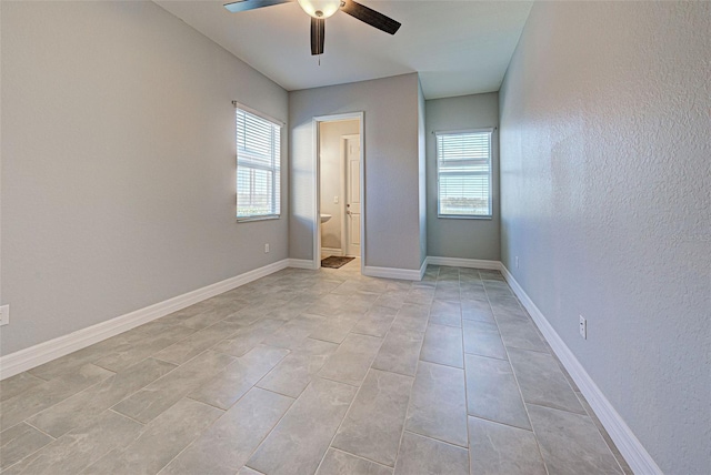 unfurnished bedroom featuring ceiling fan and ensuite bath