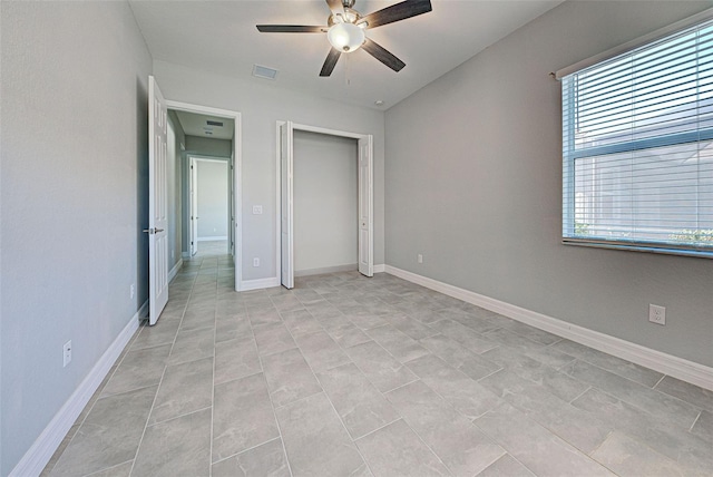 unfurnished bedroom with ceiling fan and a closet