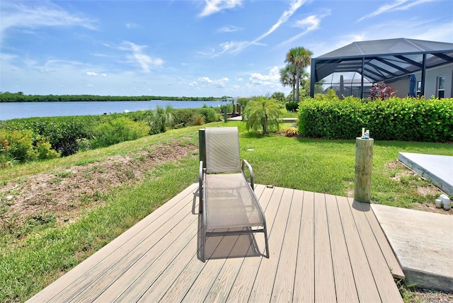 wooden deck with a yard, a water view, and glass enclosure