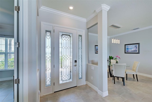 tiled foyer entrance featuring decorative columns and ornamental molding