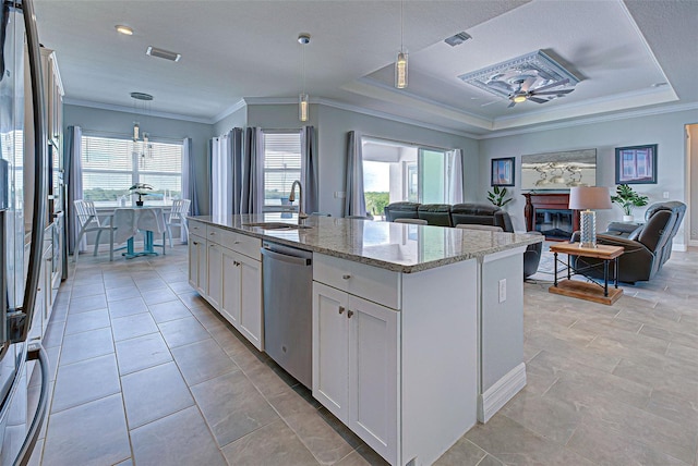 kitchen featuring sink, hanging light fixtures, a center island with sink, stainless steel dishwasher, and white cabinets