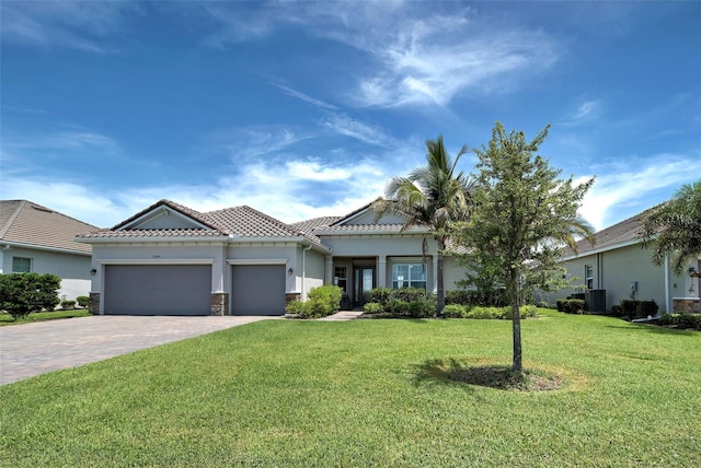 15240 Spanish Point Dr, Port Charlotte, FL 33981 - view of front of property with a tiled roof, stucco siding, decorative driveway, a front yard, and an attached garage