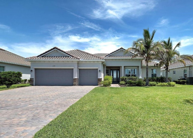 15240 Spanish Point Dr, Port Charlotte, FL 33981 - view of front of property with stucco siding, decorative driveway, a front lawn, a tile roof, and a garage