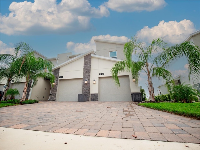 view of front facade featuring a garage and central air condition unit