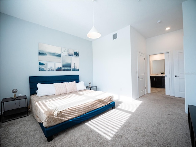 carpeted bedroom featuring ensuite bath