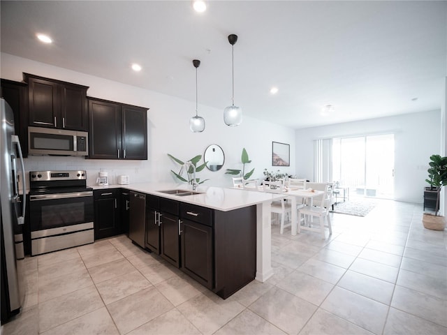 kitchen featuring sink, light tile patterned flooring, pendant lighting, and stainless steel appliances