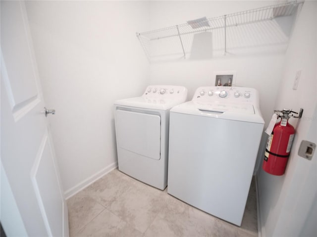 laundry area featuring washer and dryer and light tile patterned floors