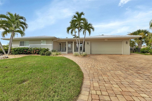 single story home featuring a garage and a front yard