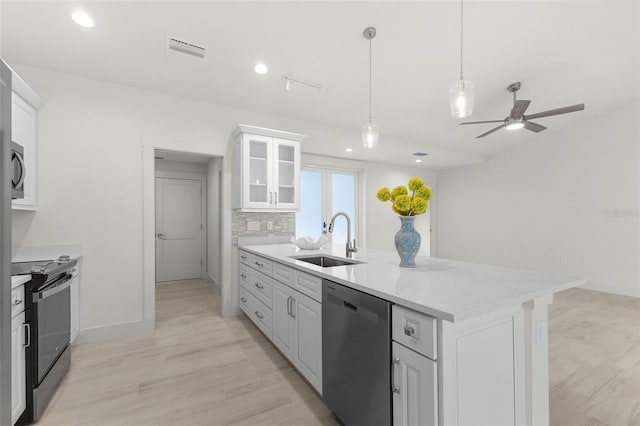 kitchen with sink, dishwasher, white cabinets, black / electric stove, and decorative backsplash