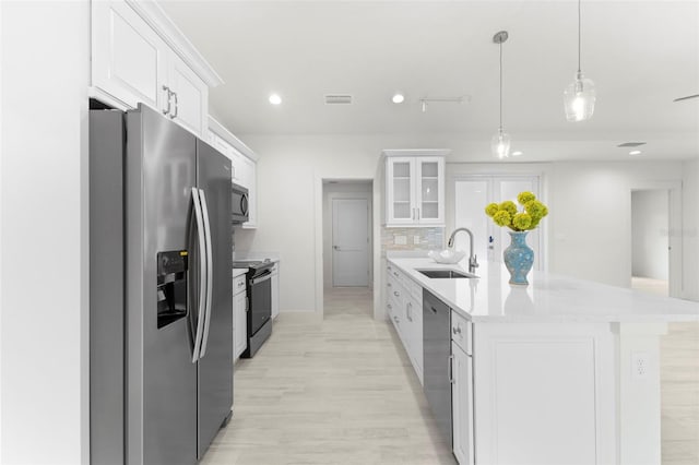 kitchen with stainless steel appliances, white cabinetry, sink, and pendant lighting