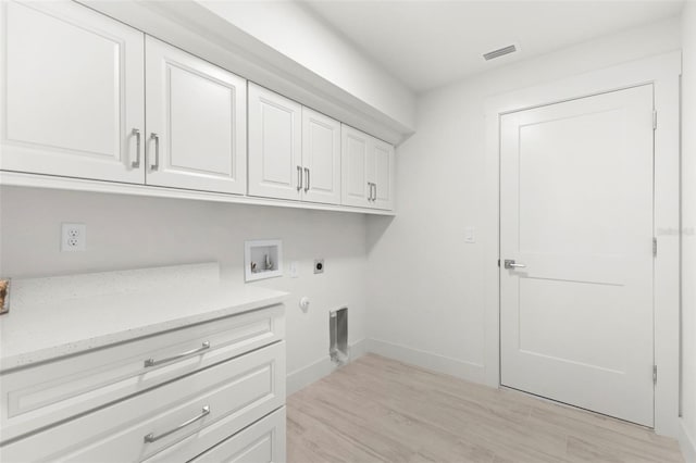 laundry room with gas dryer hookup, cabinets, washer hookup, light hardwood / wood-style floors, and electric dryer hookup