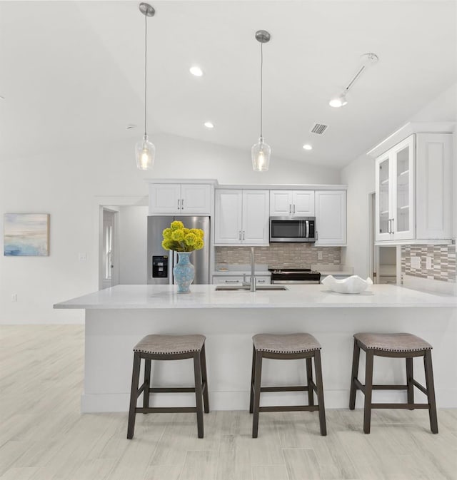 kitchen featuring white cabinetry, a kitchen bar, and appliances with stainless steel finishes