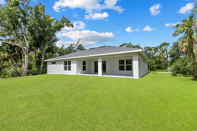 rear view of house with a yard and a patio