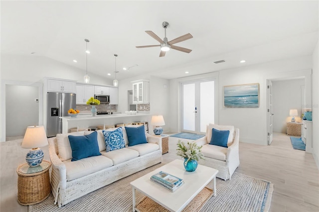 living room with french doors, ceiling fan, lofted ceiling, and light wood-type flooring