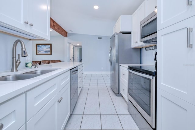 kitchen with sink, white cabinetry, appliances with stainless steel finishes, and light tile patterned floors