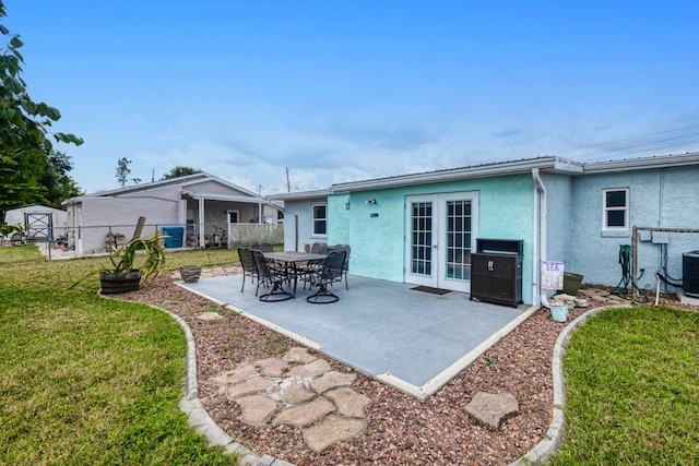 back of house featuring a storage unit, a patio, french doors, and a yard