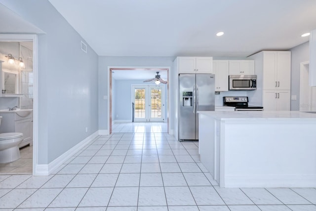 kitchen featuring ceiling fan, white cabinetry, appliances with stainless steel finishes, and light tile patterned floors