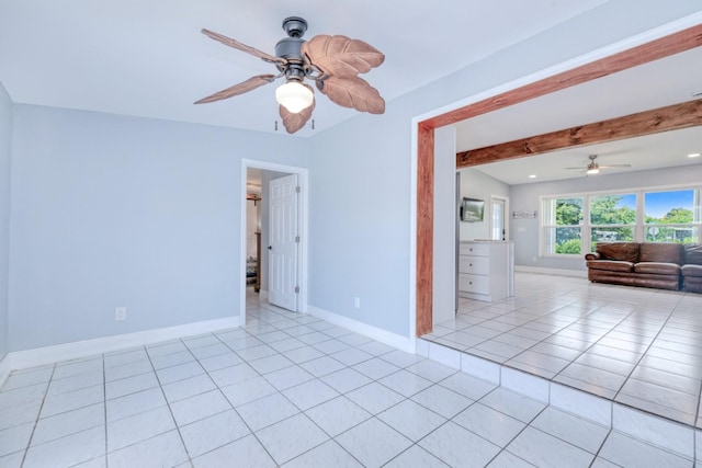 empty room featuring ceiling fan, beamed ceiling, and light tile patterned flooring