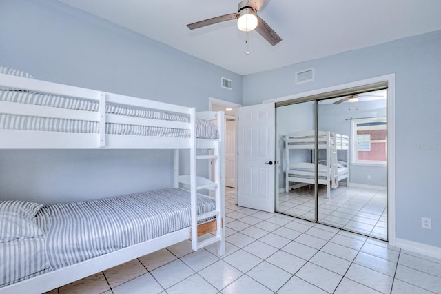 unfurnished bedroom with light tile patterned floors, ceiling fan, and a closet