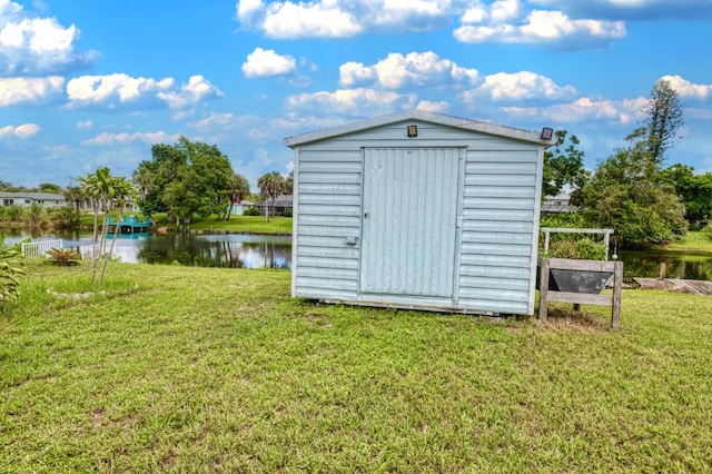 view of outbuilding with a water view and a yard