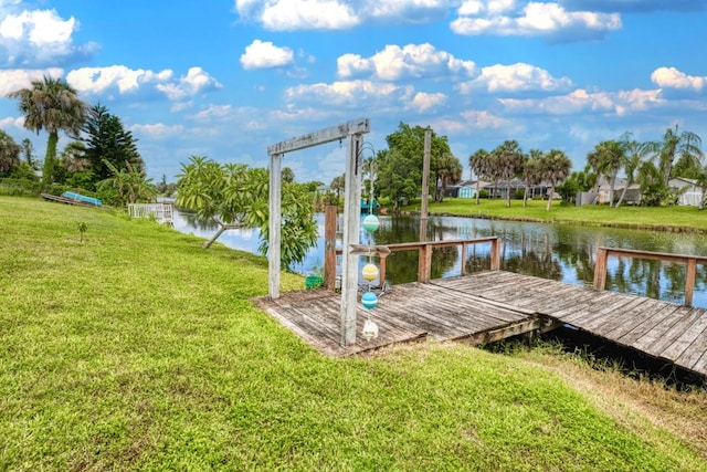 dock area featuring a lawn and a water view