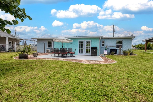 back of house featuring a patio, french doors, and a lawn