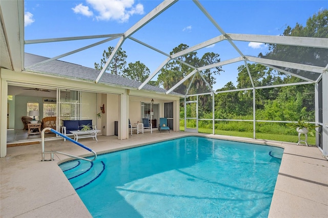 view of pool featuring ceiling fan, glass enclosure, and a patio area