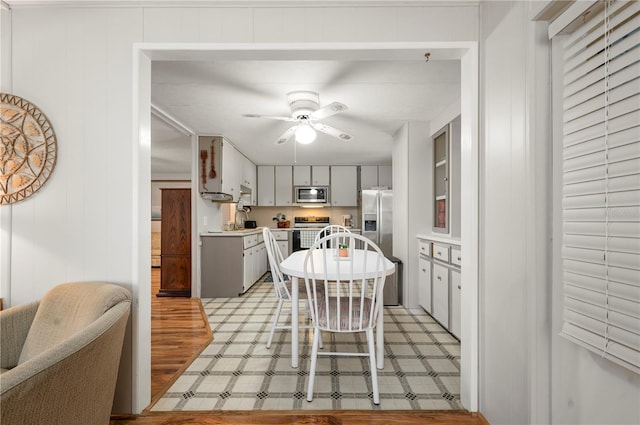 kitchen with ceiling fan, stainless steel appliances, light countertops, gray cabinets, and light floors