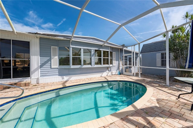 view of pool featuring a patio area, a storage unit, and a lanai