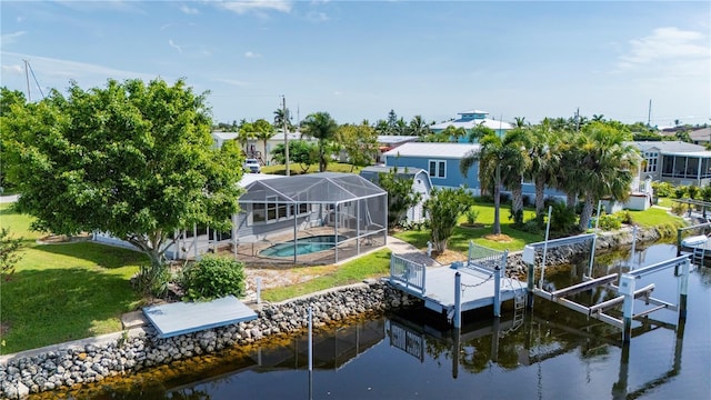 dock area featuring boat lift, a water view, a lawn, glass enclosure, and an outdoor pool