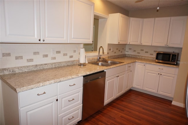 kitchen featuring stainless steel appliances, white cabinets, sink, backsplash, and dark wood-type flooring