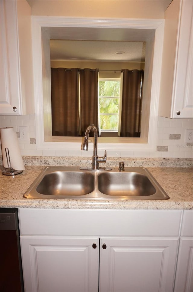 kitchen featuring sink, white cabinetry, dishwasher, and backsplash