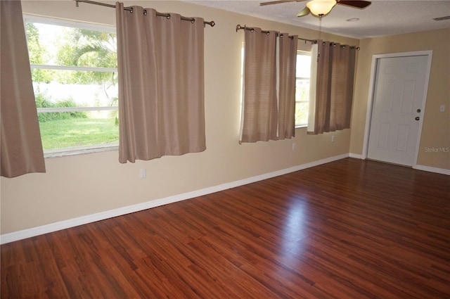 spare room with ceiling fan, a textured ceiling, and dark hardwood / wood-style flooring