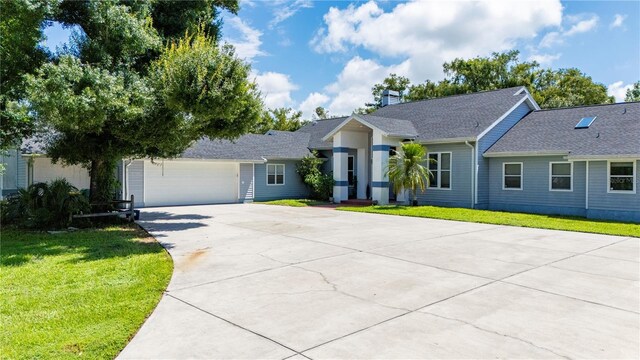 single story home featuring a garage and a front yard