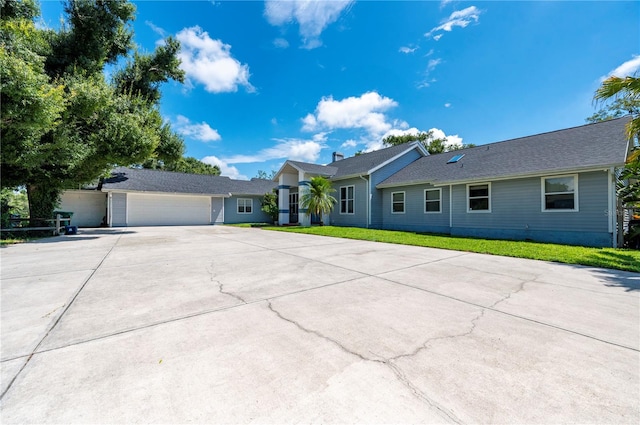 single story home featuring a garage and a front lawn