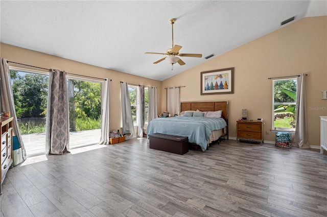 unfurnished bedroom featuring multiple windows, hardwood / wood-style floors, ceiling fan, and access to exterior