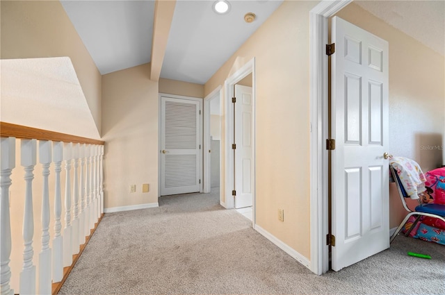 corridor with light carpet and vaulted ceiling